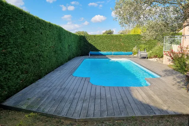 Haie haute taillée au carré le long d'une piscine
