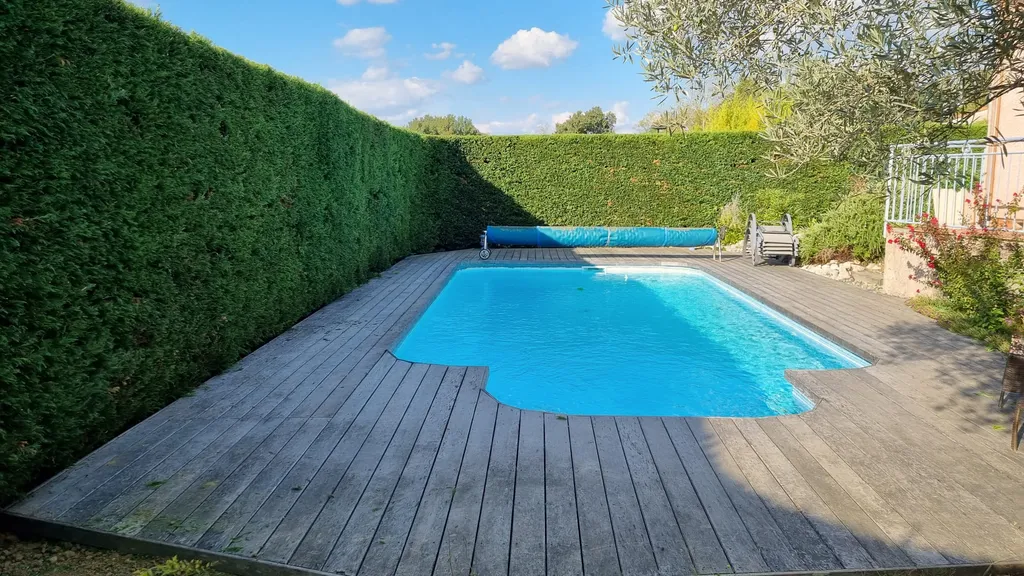 Haie haute taillée au carré le long d'une piscine